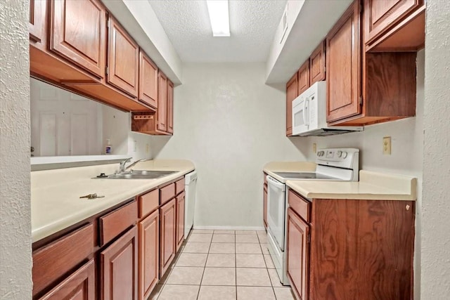 11460 Audelia Rd Unit 172, Dallas, TX 75243 - kitchen with white appliances, a textured ceiling, light countertops, light tile patterned floors, and brown cabinetry