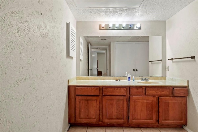 11460 Audelia Rd Unit 172, Dallas, TX 75243 - bathroom with a textured wall, double vanity, a textured ceiling, and tile patterned flooring