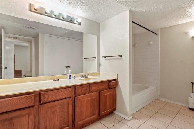 11460 Audelia Rd Unit 172, Dallas, TX 75243 - bathroom with a textured ceiling, tile patterned flooring, double vanity, shower / bathtub combination, and a textured wall
