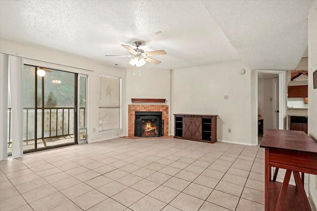 11460 Audelia Rd Unit 172, Dallas, TX 75243 - unfurnished living room featuring a textured ceiling, ceiling fan, a lit fireplace, and light tile patterned floors