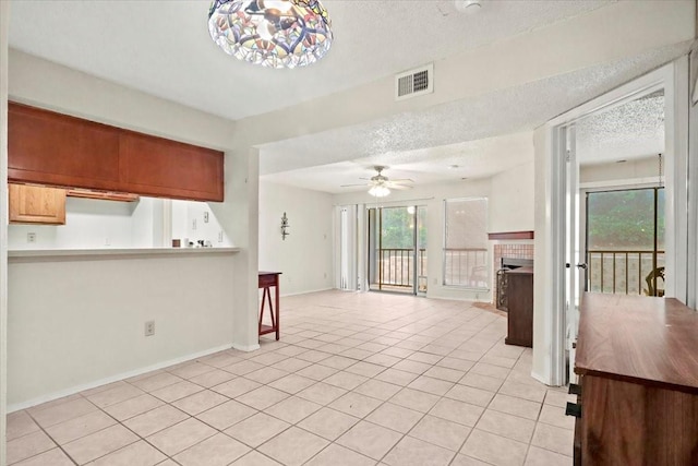 11460 Audelia Rd Unit 172, Dallas, TX 75243 - kitchen featuring light tile patterned flooring, a textured ceiling, a ceiling fan, a fireplace, and light countertops