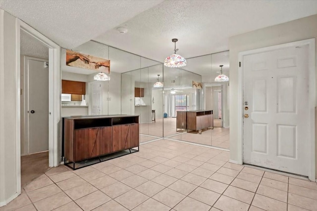11460 Audelia Rd Unit 172, Dallas, TX 75243 - kitchen with a textured ceiling, light tile patterned flooring, and decorative light fixtures