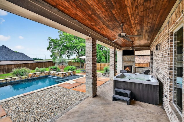 2427 Remuda Dr, Sherman, TX 75092 - fenced backyard with an outdoor stone fireplace, a hot tub, ceiling fan, a deck, and a patio