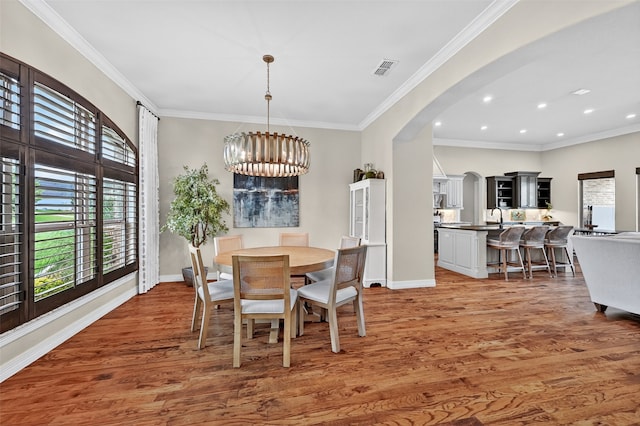 2427 Remuda Dr, Sherman, TX 75092 - dining area featuring plenty of natural light, arched walkways, light wood-style flooring, a chandelier, and crown molding