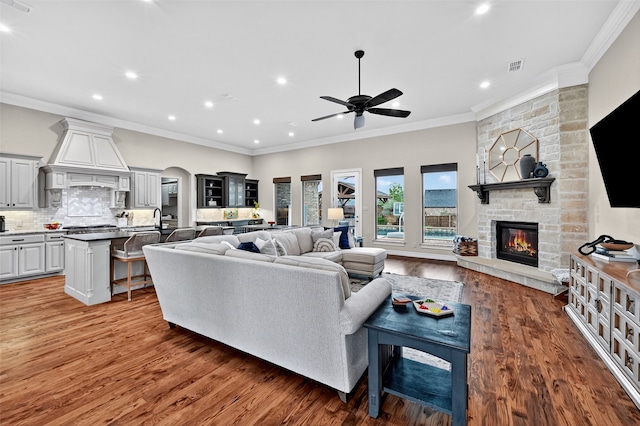 2427 Remuda Dr, Sherman, TX 75092 - living area featuring a stone fireplace, a ceiling fan, recessed lighting, ornamental molding, and wood finished floors