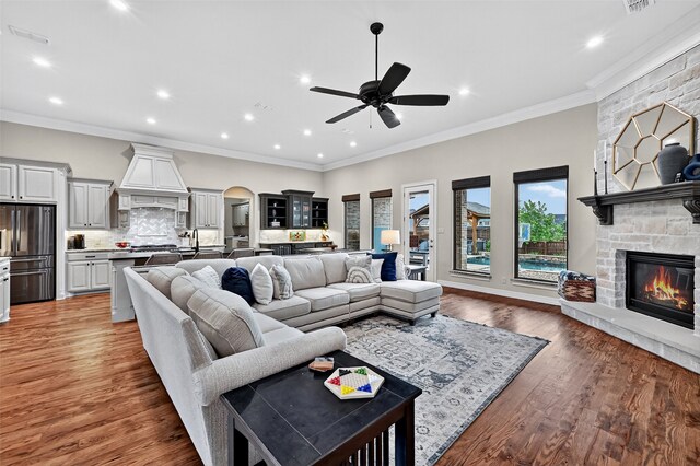 2427 Remuda Dr, Sherman, TX 75092 - living room with a fireplace, ceiling fan, recessed lighting, arched walkways, and light wood-style floors