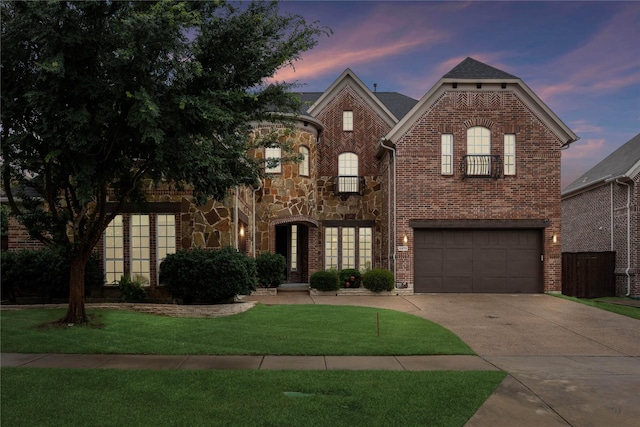 6873 Martel Pl, Frisco, TX 75035 - view of front of house featuring driveway, brick siding, a front lawn, an attached garage, and stone siding