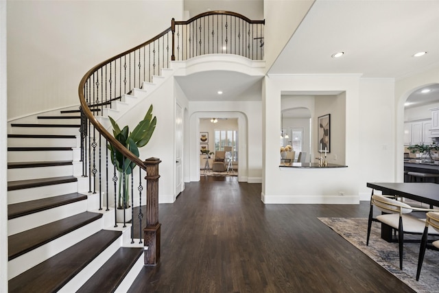 6873 Martel Pl, Frisco, TX 75035 - foyer entrance featuring arched walkways, wood finished floors, stairs, recessed lighting, and a towering ceiling
