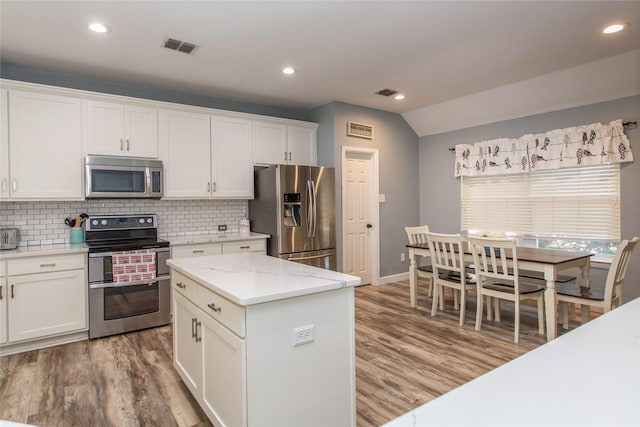 5216 Copper Creek Dr, Fort Worth, TX 76244 - kitchen featuring stainless steel appliances, backsplash, light wood-style floors, white cabinets, and vaulted ceiling