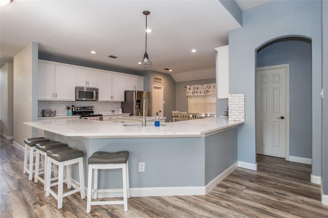 5216 Copper Creek Dr, Fort Worth, TX 76244 - kitchen with appliances with stainless steel finishes, backsplash, white cabinets, wood finished floors, and recessed lighting