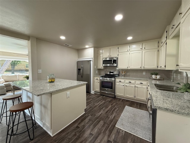 2849 Spruce Park Dr, Richland Hills, TX 76118 - kitchen featuring stainless steel appliances, white cabinetry, backsplash, dark wood-style floors, and recessed lighting