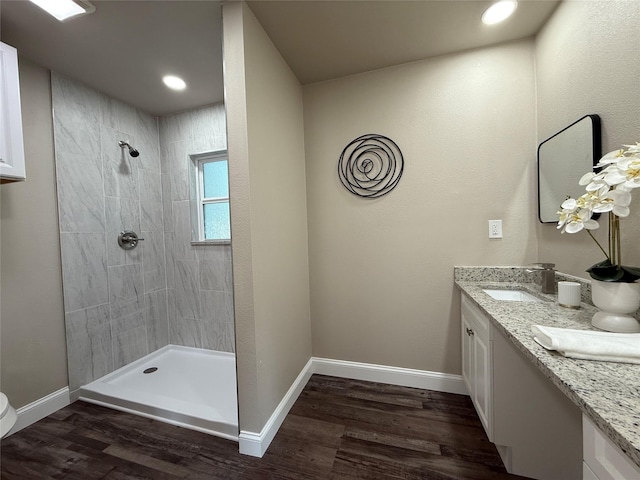 2849 Spruce Park Dr, Richland Hills, TX 76118 - bathroom featuring tiled shower, double vanity, wood finished floors, and recessed lighting