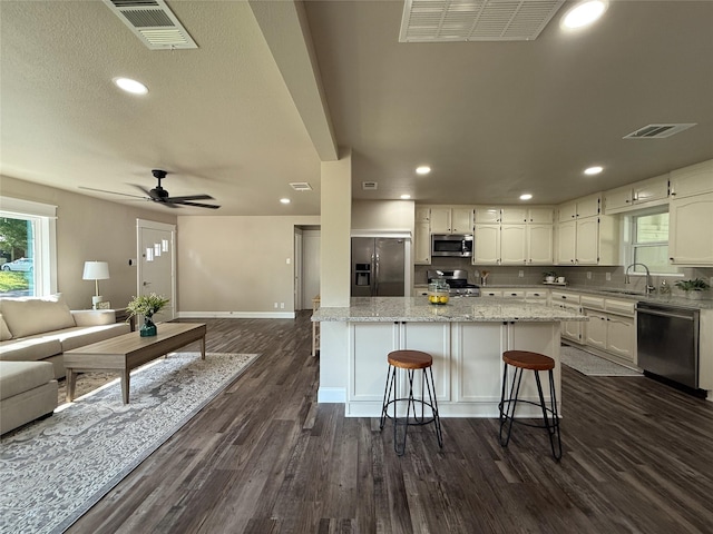 2849 Spruce Park Dr, Richland Hills, TX 76118 - kitchen featuring appliances with stainless steel finishes, open floor plan, dark wood-style flooring, white cabinets, and recessed lighting