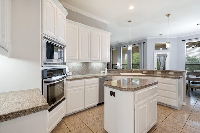 3217 S Bay Breeze Ln, Fort Worth, TX 76179 - kitchen with stainless steel appliances, a peninsula, a kitchen island, decorative backsplash, and light tile patterned floors