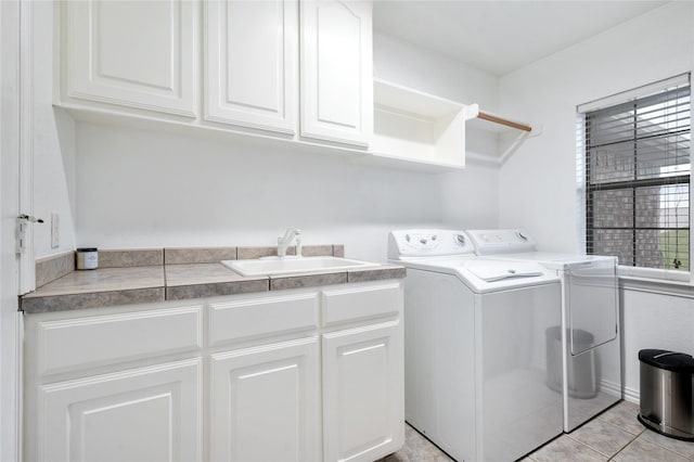 3217 S Bay Breeze Ln, Fort Worth, TX 76179 - laundry room featuring washer and dryer, cabinet space, and light tile patterned floors