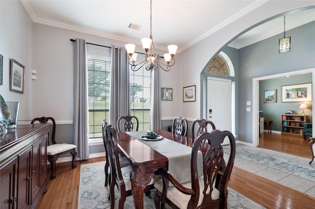 3217 S Bay Breeze Ln, Fort Worth, TX 76179 - dining room featuring arched walkways, ornamental molding, a chandelier, and light wood-style floors