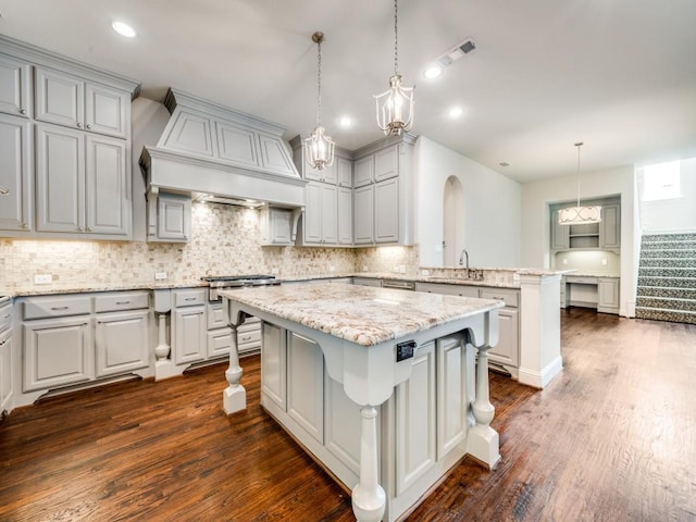 2911 Blackthorn Dr, Prosper, TX 75078 - kitchen with a kitchen island, dark wood-style floors, a peninsula, tasteful backsplash, and premium range hood