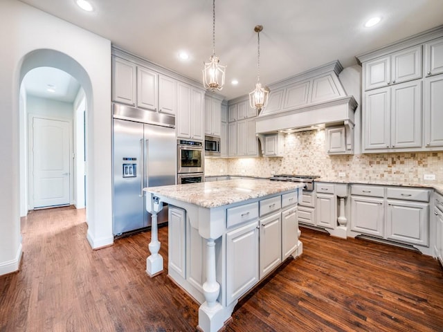 2911 Blackthorn Dr, Prosper, TX 75078 - kitchen featuring built in appliances, a center island, arched walkways, tasteful backsplash, and recessed lighting