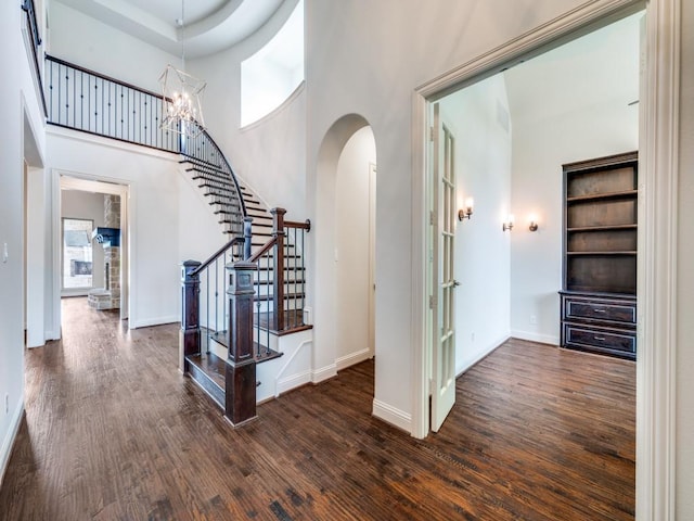 2911 Blackthorn Dr, Prosper, TX 75078 - entrance foyer featuring arched walkways, stairs, dark wood-type flooring, a high ceiling, and a chandelier