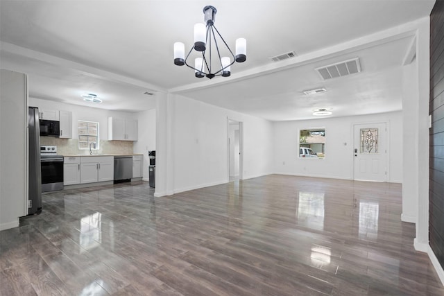 4236 Virginia Ln, Fort Worth, TX 76103 - unfurnished living room with healthy amount of natural light, a chandelier, and dark wood-style floors