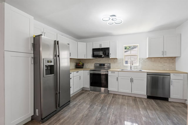 4236 Virginia Ln, Fort Worth, TX 76103 - kitchen with stainless steel appliances, light countertops, tasteful backsplash, wood finished floors, and white cabinetry