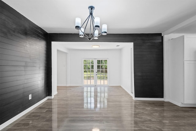 4236 Virginia Ln, Fort Worth, TX 76103 - unfurnished dining area with a chandelier, wooden walls, french doors, and wood finished floors