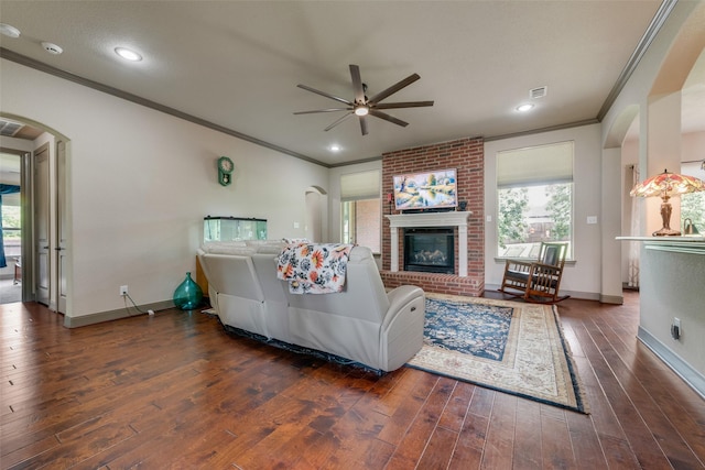 206 Hidden Meadow Cir, Midlothian, TX 76065 - living area featuring crown molding, ceiling fan, healthy amount of natural light, arched walkways, and a fireplace