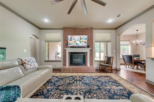 206 Hidden Meadow Cir, Midlothian, TX 76065 - living room with wood finished floors, crown molding, a ceiling fan, a chandelier, and arched walkways