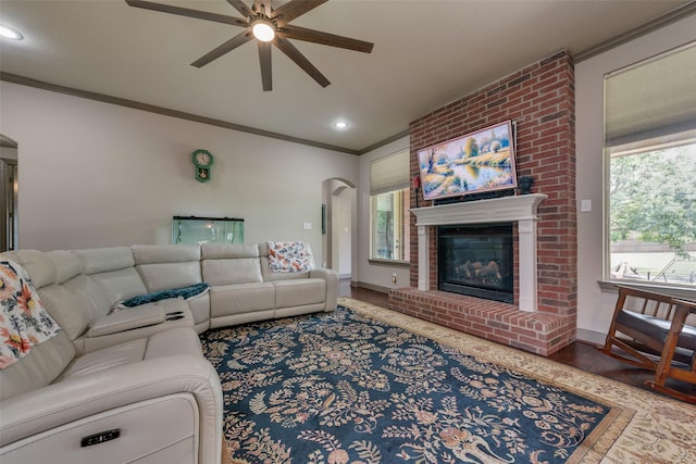206 Hidden Meadow Cir, Midlothian, TX 76065 - living room featuring ceiling fan, ornamental molding, plenty of natural light, arched walkways, and a fireplace