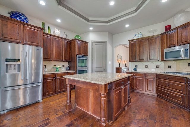 206 Hidden Meadow Cir, Midlothian, TX 76065 - kitchen with stainless steel appliances, backsplash, arched walkways, dark wood-style floors, and a center island