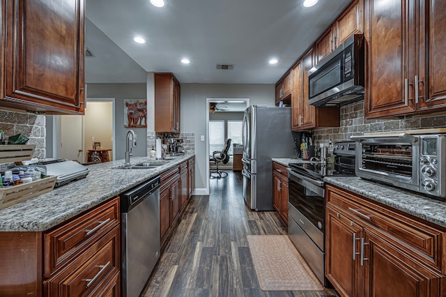 211 Willow Creek Ct, Mansfield, TX 76063 - kitchen with appliances with stainless steel finishes, dark wood-style floors, backsplash, recessed lighting, and a peninsula