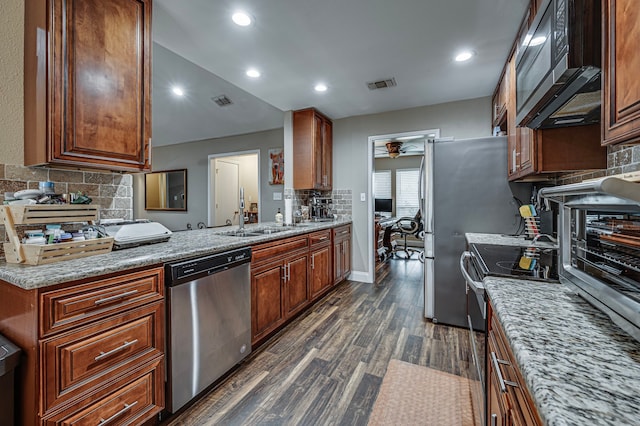 211 Willow Creek Ct, Mansfield, TX 76063 - kitchen with stainless steel dishwasher, tasteful backsplash, dark wood-type flooring, black microwave, and range