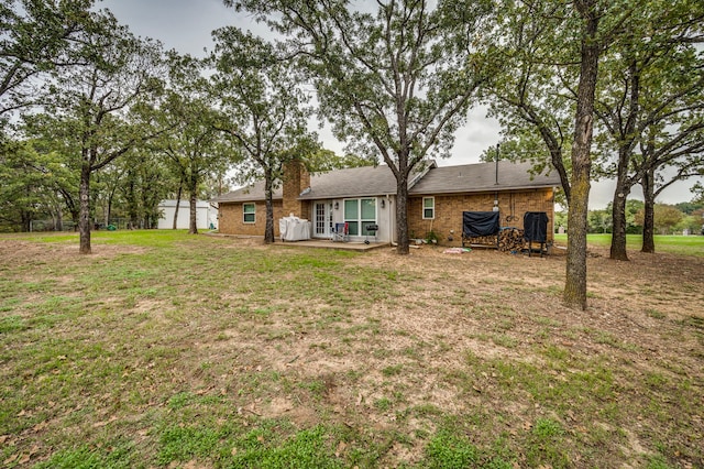 211 Willow Creek Ct, Mansfield, TX 76063 - rear view of property featuring a yard, brick siding, a chimney, and a patio area