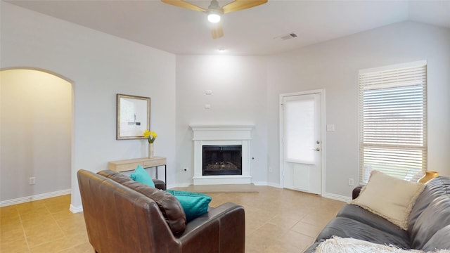 751 Kirby Dr, Argyle, TX 76226 - living area with light tile patterned flooring, ceiling fan, a fireplace with raised hearth, arched walkways, and vaulted ceiling
