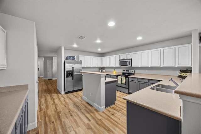 2316 Cavalry Dr, Fort Worth, TX 76177 - kitchen with appliances with stainless steel finishes, recessed lighting, light wood-type flooring, a kitchen island, and white cabinetry