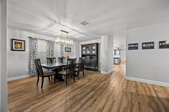 2316 Cavalry Dr, Fort Worth, TX 76177 - dining room featuring a textured ceiling, a chandelier, wood finished floors, and a ceiling fan