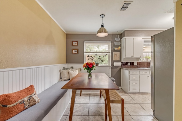 4204 Shipley Ct, Benbrook, TX 76116 - dining area featuring ornamental molding, light tile patterned floors, and wainscoting