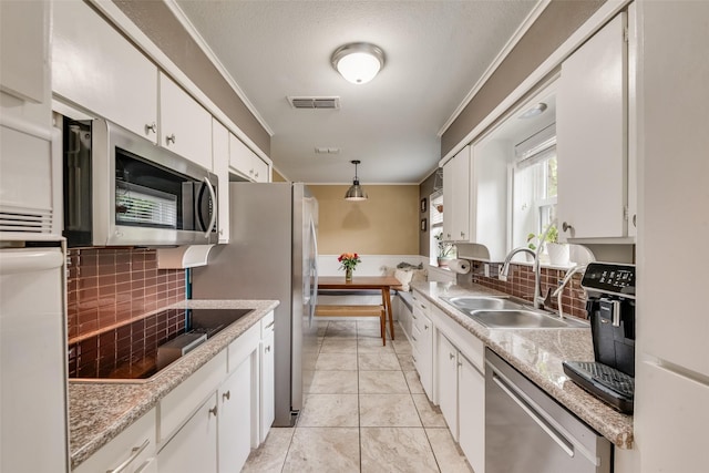 4204 Shipley Ct, Benbrook, TX 76116 - kitchen with appliances with stainless steel finishes, white cabinets, crown molding, decorative backsplash, and light countertops
