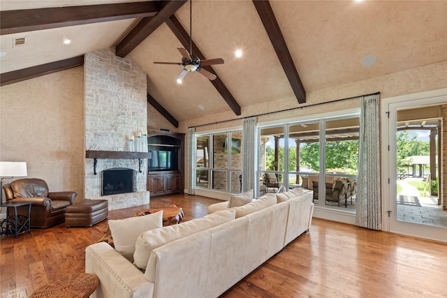 229 Lakeside Dr, Malakoff, TX 75148 - living area with beamed ceiling, wood finished floors, high vaulted ceiling, a fireplace, and ceiling fan