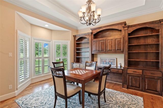229 Lakeside Dr, Malakoff, TX 75148 - dining space featuring built in study area, a chandelier, light wood-type flooring, ornamental molding, and a raised ceiling