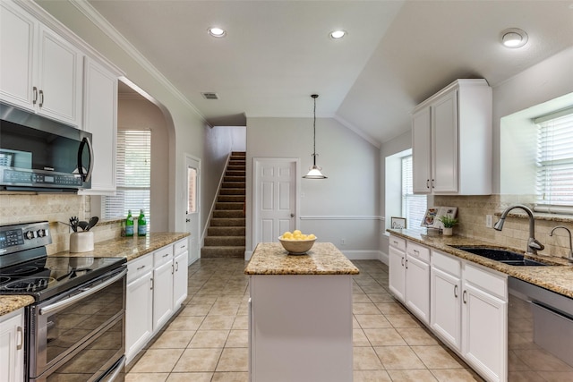 426 Bell Dr, Wylie, TX 75098 - kitchen with appliances with stainless steel finishes, a kitchen island, backsplash, white cabinets, and vaulted ceiling
