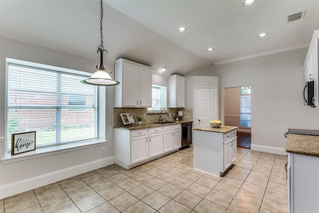 426 Bell Dr, Wylie, TX 75098 - kitchen featuring black appliances, a center island, white cabinets, light tile patterned floors, and tasteful backsplash