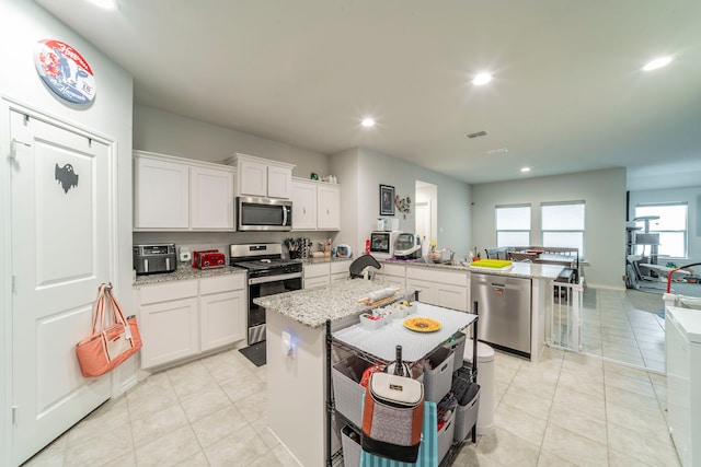 756 Loomis Trl, Justin, TX 76247 - kitchen featuring stainless steel appliances, recessed lighting, a peninsula, white cabinetry, and light tile patterned floors