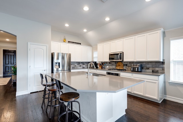 1728 Karma Dr, Wylie, TX 75098 - kitchen with stainless steel appliances, arched walkways, lofted ceiling, tasteful backsplash, and a kitchen island with sink