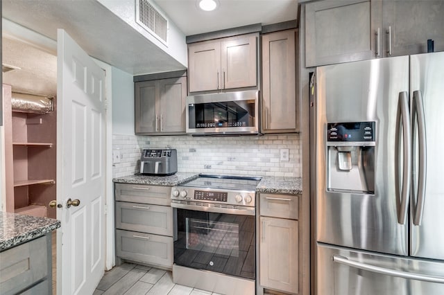 3412 Forest Creek Dr, Fort Worth, TX 76123 - kitchen featuring stainless steel appliances, tasteful backsplash, light stone countertops, and light wood-style flooring