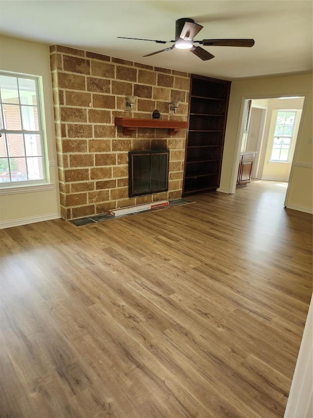 1721 Monaco Dr, Arlington, TX 76010 - unfurnished living room featuring ceiling fan, wood finished floors, and a large fireplace