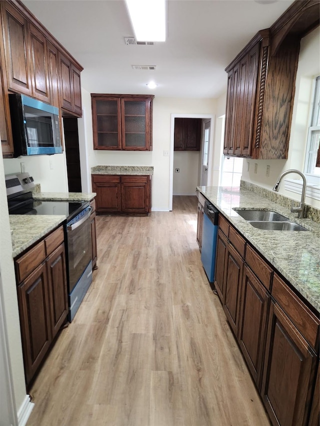 1721 Monaco Dr, Arlington, TX 76010 - kitchen with appliances with stainless steel finishes, light wood finished floors, light stone counters, and glass insert cabinets