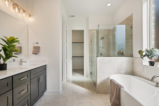 2105 Oak Haven Ct, Garland, TX 75044 - bathroom featuring marble finish floors, double vanity, a stall shower, a garden tub, and a walk in closet