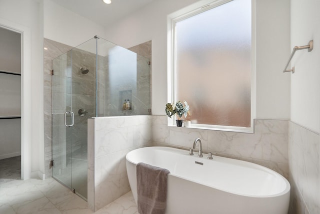 2105 Oak Haven Ct, Garland, TX 75044 - full bathroom featuring a stall shower, a soaking tub, marble finish flooring, and tile walls
