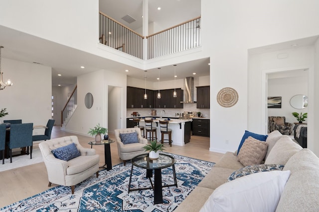 2105 Oak Haven Ct, Garland, TX 75044 - living room featuring light wood-type flooring, stairway, a chandelier, a towering ceiling, and recessed lighting